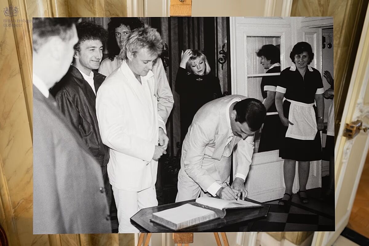Freddie pasirašo ambasados svečių knygoje