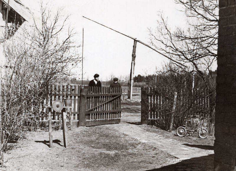 Mažieji kiemo vartai ir šulinys su svirtimi. Už vartų stovi tėvelis Georg Klumbies ir žentas, dukros Magdalenos vyras Ernst Johann Piklaps, 1978 m.