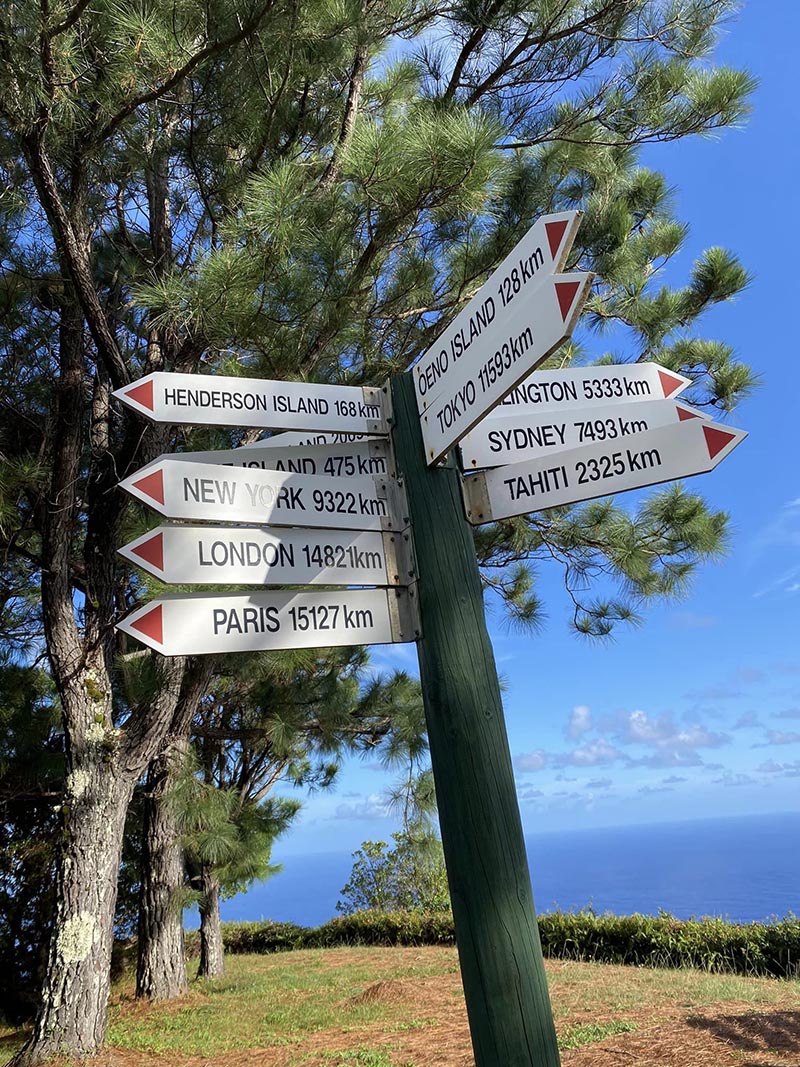 Aukščiausiame Pitcairn salos taške nuorodos žymi atstumus iki didžiausių pasaulio miestų.