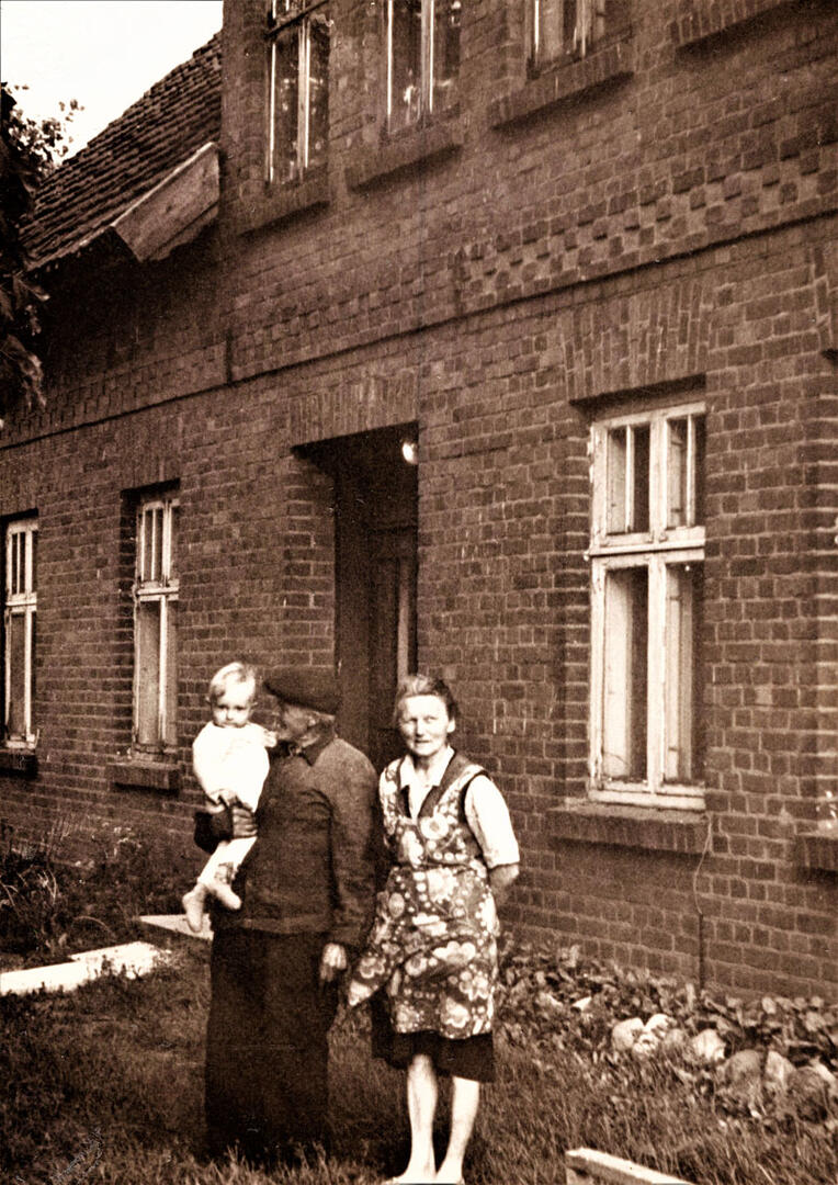 Seneliai Mėta Pažėraitė-Klumbienė ir Jurgis Klumbys su vaikaičiu Arnold prie namų  Miškogalių (dabar Petrelių) kaime, 1976 m.