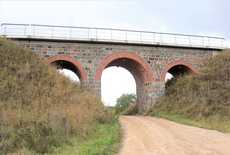 1892 m. tiesiant geležinkelio liniją iš Mėmelio į Bajorus pastatytas arkinis viadukas. Piečiau jo yra ir tiltas.