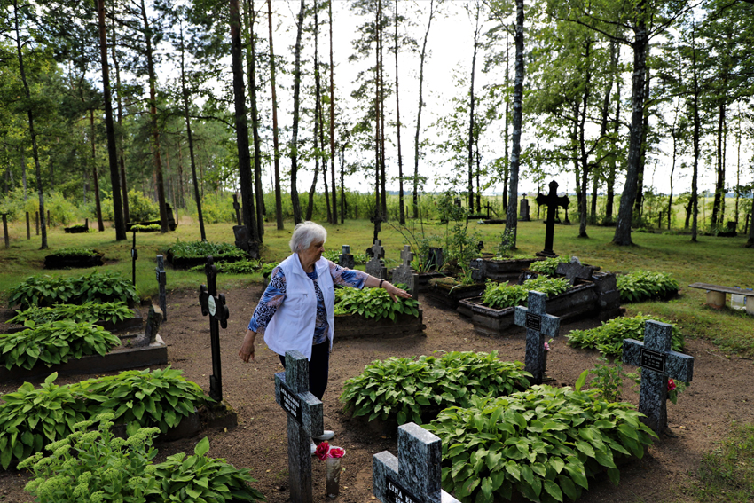 M. Klumbytė-Piklaps prie savo tėvelių kapų Miškogalių kapinėse. Toliau matosi senelių Pažėrų ir trijų mamos seserų kapeliai. Iš viso kapinėse ilsisi 12 Pažėrų šeimos narių.