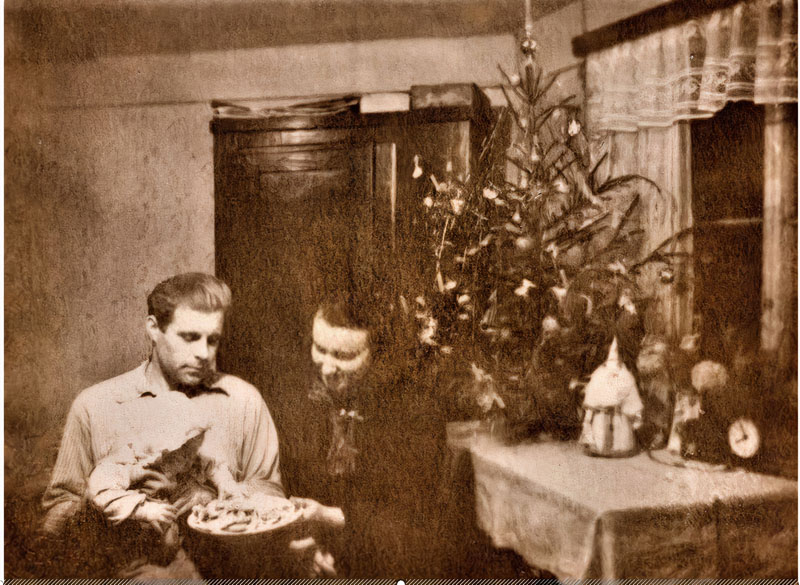 Šv. Kalėdos Grubertų namuose Klaipėdoje. Ant Vilio Gruberto rankų - dukrelė Erika. Mama Trūdė (Gertrud) Grubert (gim. Kapust) vaišina namiškius savo keptais sausainiais, 1960 m.