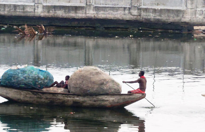 Nuotraukoje užfiksuoti vietos gyventojai, gabenantys prekes į turgų.