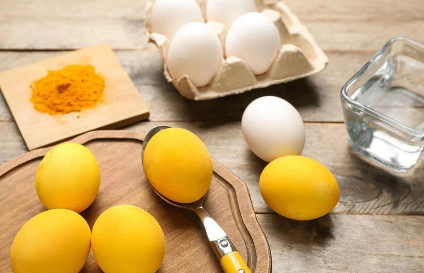 Ryškiai geltoni kiaušiniai ant Velykų stalo