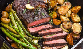 Keptuvėje keptas česnakinis sviesto kepsnys su traškiomis bulvėmis ir šparagais