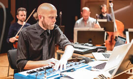 Paaugliai mobiliaisiais telefonais gros kartu su orkestru