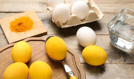 Ryškiai geltoni kiaušiniai ant Velykų stalo