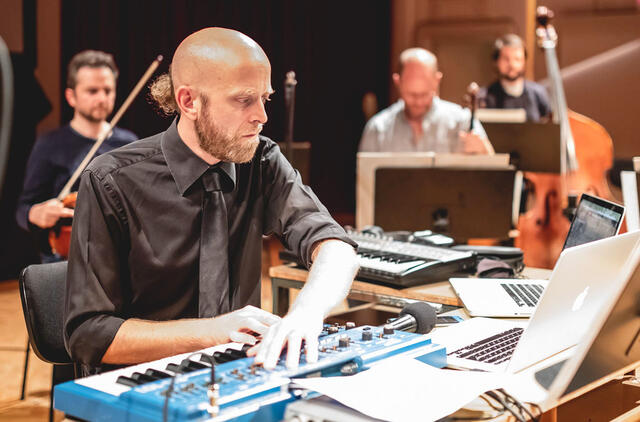 Paaugliai mobiliaisiais telefonais gros kartu su orkestru