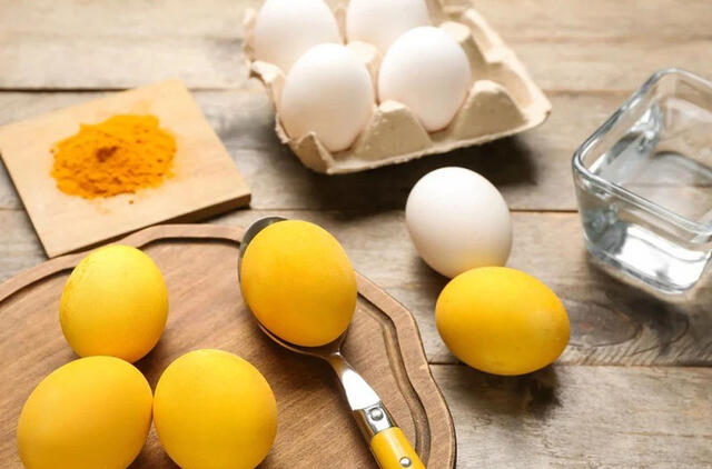 Ryškiai geltoni kiaušiniai ant Velykų stalo